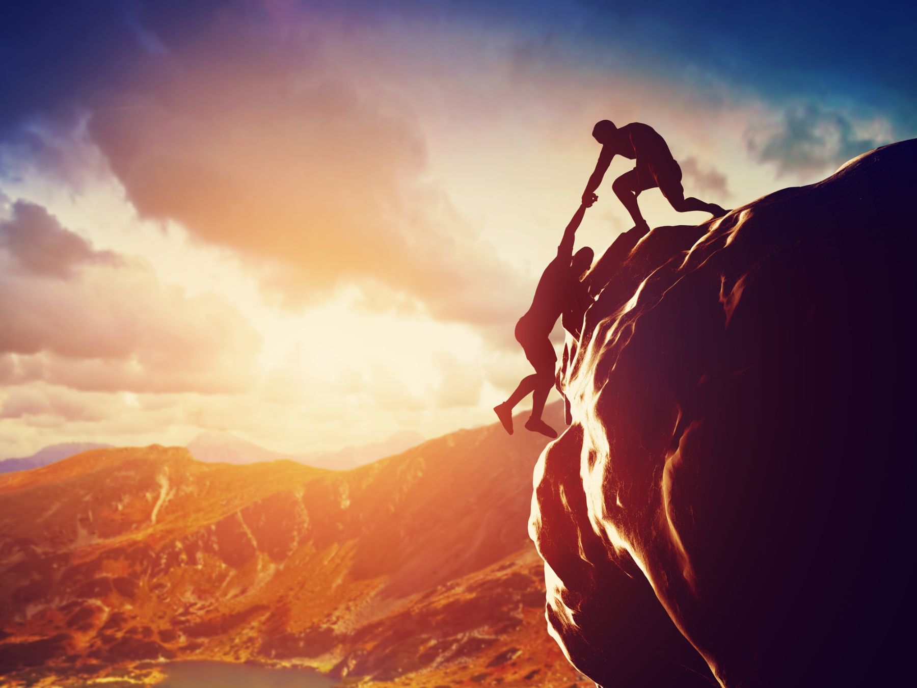 Person helping climber on mountain