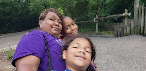 Three people posing for a picture at the zoo.