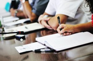 Coworkers taking notes at a meeting