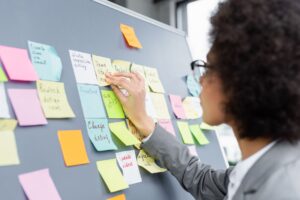 Woman looking at post-it notes on a board