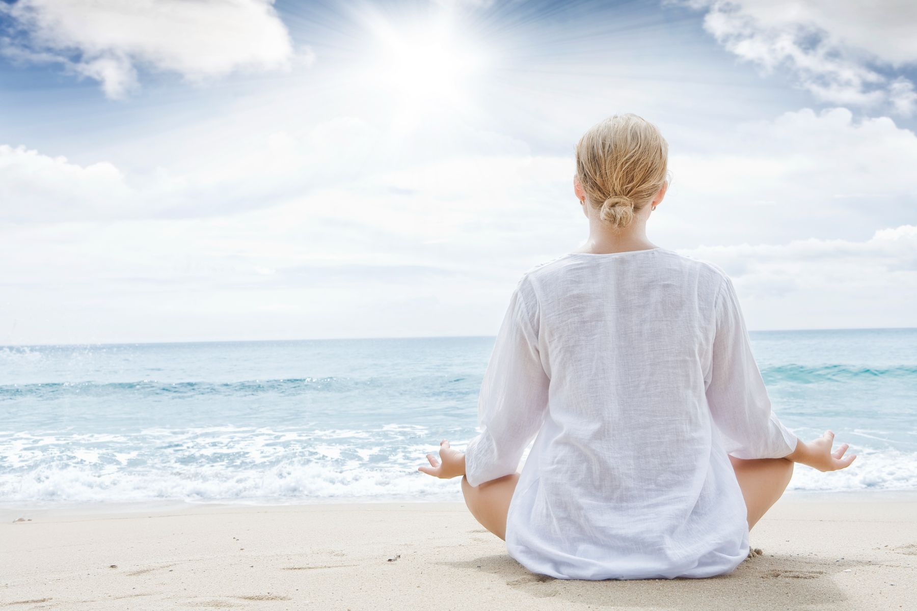 Woman meditating at a beach