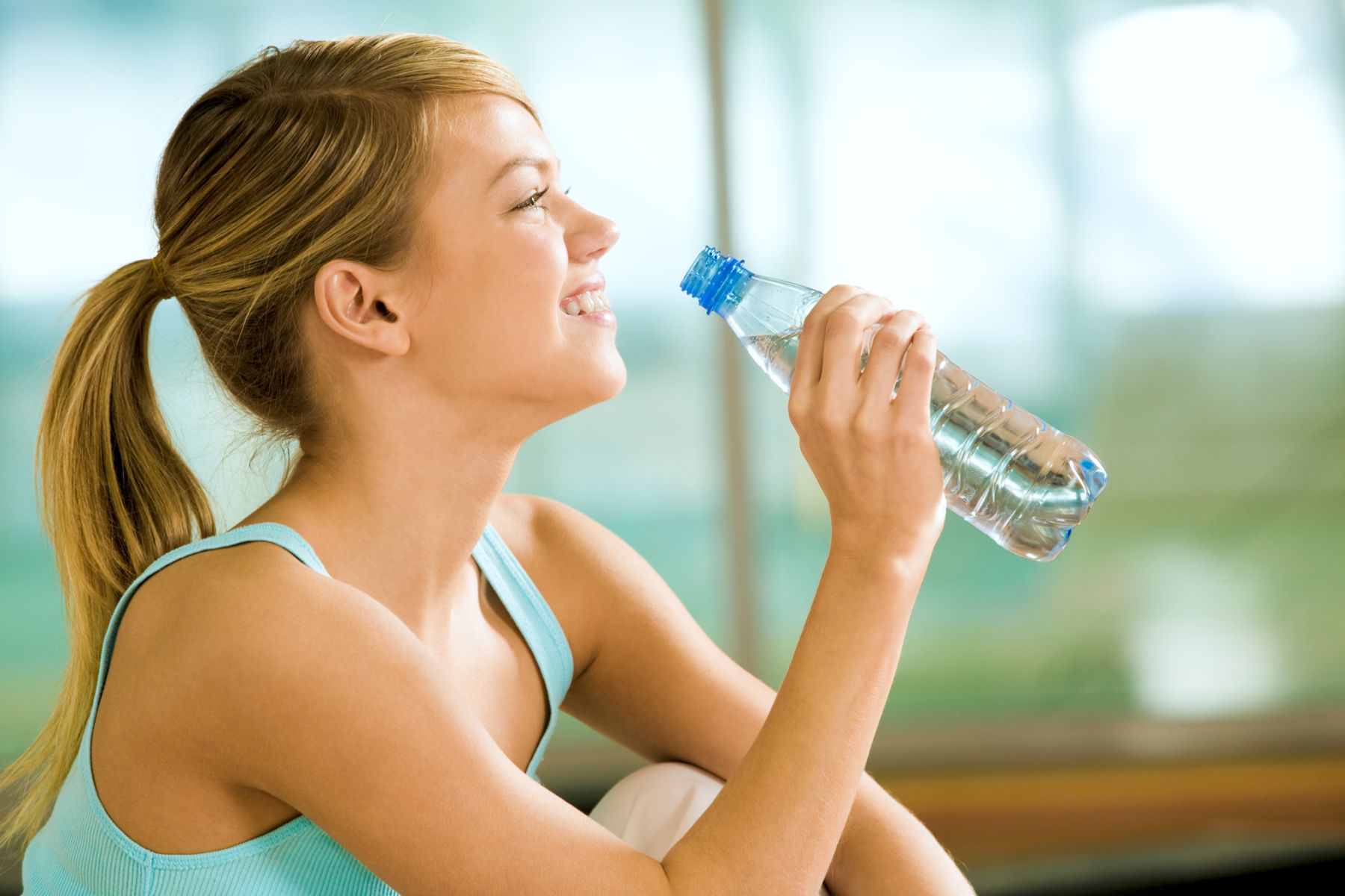 woman at the gym and drinking water