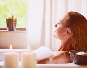 woman in the bath relaxing with some candles