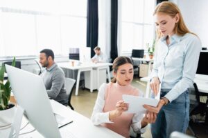 two women in an office looking at a report