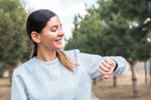 woman looking at her smart watch, tracking her steps