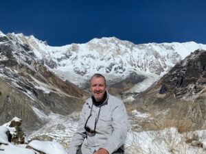 Nick Taylor posing for a picture in front of mountains.
